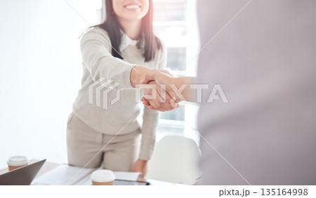 Business people, staff and handshake in a meeting, cooperation and partnership with teamwork. Closeup, woman and coworkers shaking hands, collaboration or agreement with welcome, support or thank you 135164998