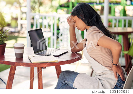 Woman in pain with laptop at garden table, outdoor cafe or plant shop with stress, burnout and back ache. Mental health, small business owner and computer, worry with injury in florist restaurant. Woman in pain with laptop at garden table, outdoor cafe or plant shop with stress, burnout and back ache. Mental health, small business owner and computer, worry with injury in florist restaurant. 135165033