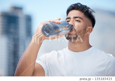 Man, fitness and drinking water in city workout, cardio exercise or running for sustainability outdoors. Thirsty male person, athlete or runner with drink for hydration, rest or break in urban town 135165415
