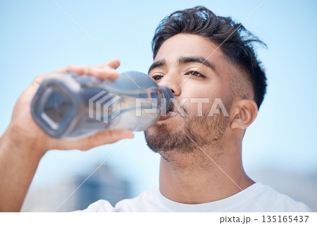 Man, fitness and drinking water in city for sustainability after running exercise, workout or training outdoors. Thirsty male person, athlete or runner with drink for hydration, rest or break in town 135165437