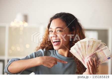 Happy woman is pointing at cash fan, savings and finance with success and celebrate financial goals. Budget, winning and wealth with money, investment and female person winner with salary bonus Happy woman is pointing at cash fan, savings and finance with success and celebrate financial goals. Budget, winning and wealth with money, investment and female person winner with salary bonus 135165819