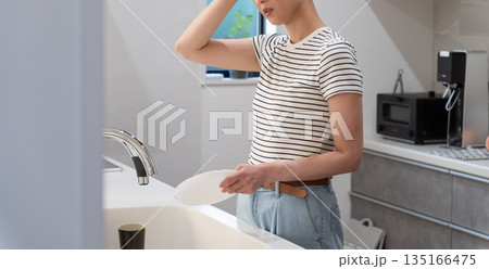 キッチンで皿洗いをする女性 135166475