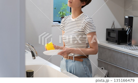 キッチンで皿洗いをする女性 キッチンで皿洗いをする女性 135166479