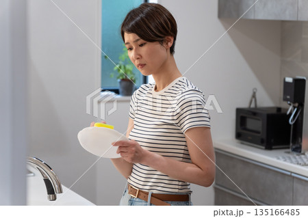 キッチンで皿洗いをする女性 キッチンで皿洗いをする女性 135166485