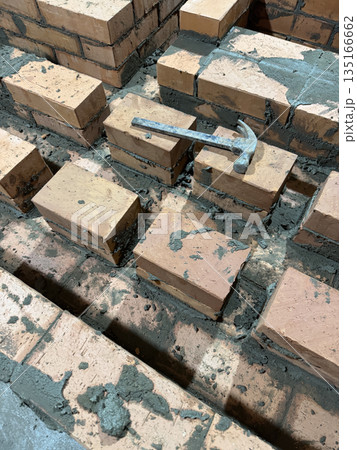 Fresh brickwork of a heating stove bench. The contours of smoke channels are visible. Close-up. 135166662