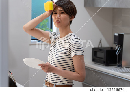 キッチンで皿洗いをする女性 135166744