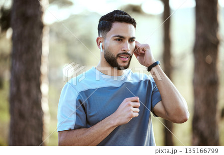 Fitness, man and outdoor with earphones for music on run or workout for motivation. Male athlete person or runner listening to audio in nature forest for training exercise, running and wellness goals Fitness, man and outdoor with earphones for music on run or workout for motivation. Male athlete person or runner listening to audio in nature forest for training exercise, running and wellness goals 135166799