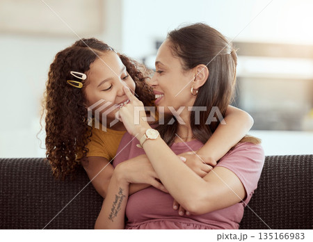 Hug, love and mother with girl on a sofa, playing and happy in their home together, sweet and care. Family, embrace and child with parent in living room, smile and hugging while having fun on weekend 135166983