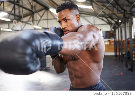 African man, boxing and punching in gym for fitness, focus or training for growth, goal and health for competition. African guy, boxer and gloves for exercise, wellness or martial arts club for sport African man, boxing and punching in gym for fitness, focus or training for growth, goal and health for competition. African guy, boxer and gloves for exercise, wellness or martial arts club for sport 135167058