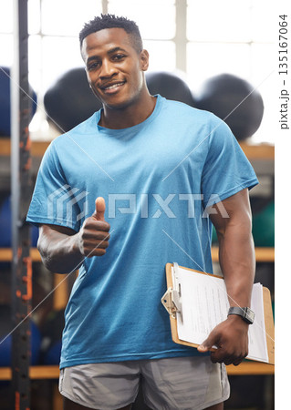 Thumbs up, portrait and fitness man in gym, clipboard and checklist for workout results, progress and like, yes or okay hand. African person, athlete or bodybuilder paperwork and thank you sign 135167064