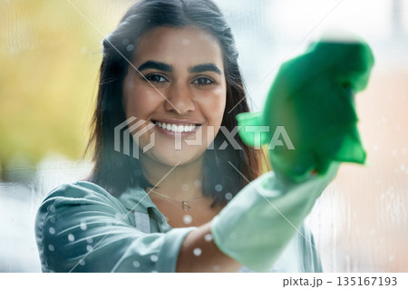 Housekeeping, portrait and cleaner cleaning the window with a cloth by her home or apartment. Female maid, housekeeper or wife washing the glass door with detergent product for bacteria, dirt or dust 135167193
