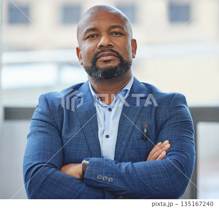Confidence, crossed arms and portrait of a businessman in his office with a serious face expression. Career, professional and confident African male executive ceo posing in the modern workplace. Confidence, crossed arms and portrait of a businessman in his office with a serious face expression. Career, professional and confident African male executive ceo posing in the modern workplace. 135167240