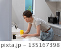 キッチンで皿洗いをする体調不良の女性 135167398