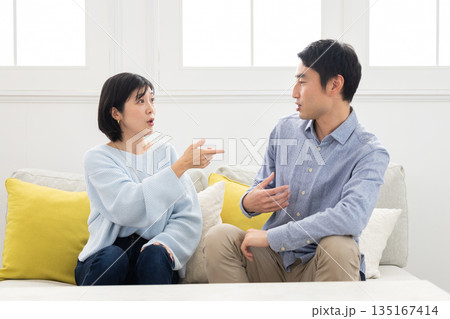 ソファに座り口論する夫婦 ソファに座り口論する夫婦 135167414