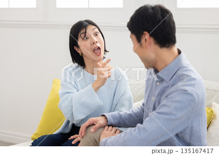 ソファに座り口論する夫婦 ソファに座り口論する夫婦 135167417