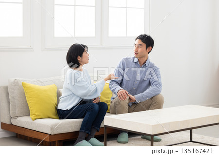 ソファに座り口論する夫婦 ソファに座り口論する夫婦 135167421