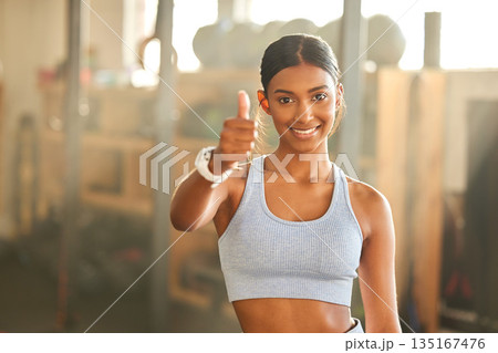 Gym, portrait or Indian woman with thumbs up in fitness training with positive mindset or motivation. Encouragement, support or happy personal trainer in workout with like hand sign or thumb up 135167476