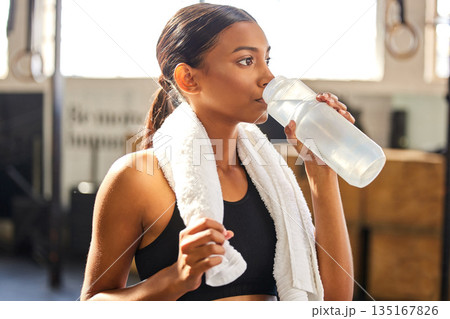 Tired, fitness or Indian woman drinking water at gym in training, workout or exercise to hydrate her body. Fatigue, wellness or thirsty girl with bottle for healthy liquid hydration on resting break Tired, fitness or Indian woman drinking water at gym in training, workout or exercise to hydrate her body. Fatigue, wellness or thirsty girl with bottle for healthy liquid hydration on resting break 135167826