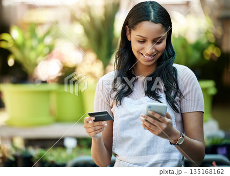 Credit card, phone and a woman with a payment at a nursery for stock, plants or shopping on the web. Ecommerce, pay and a happy business owner or customer buying a plant on sale on a mobile app Credit card, phone and a woman with a payment at a nursery for stock, plants or shopping on the web. Ecommerce, pay and a happy business owner or customer buying a plant on sale on a mobile app 135168162