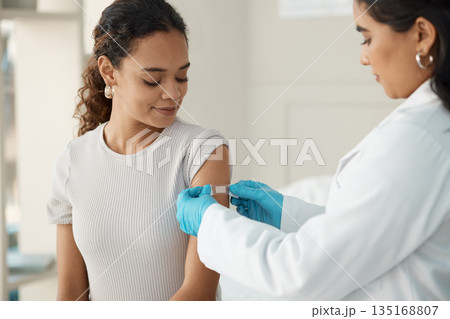 Doctor, patient and plaster for vaccination at a clinic for health and wellness for virus. Healthcare, vaccine and patch at the hospital with cure for safety with medical results with medicine. Doctor, patient and plaster for vaccination at a clinic for health and wellness for virus. Healthcare, vaccine and patch at the hospital with cure for safety with medical results with medicine. 135168807