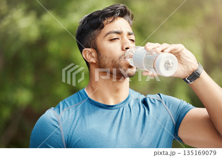 Fitness, man with in park, drinking water and hiking in nature for health and wellness during exercise. Drink, bottle and fit male on hike with trees for body workout, energy and training mindset. Fitness, man with in park, drinking water and hiking in nature for health and wellness during exercise. Drink, bottle and fit male on hike with trees for body workout, energy and training mindset. 135169079