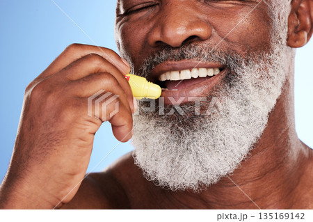 Skincare, lip balm and black man with cosmetics, smile and dermatology against a blue studio background. Male person, mature guy and happy model with grooming for the mouth, lip gloss and treatment 135169142