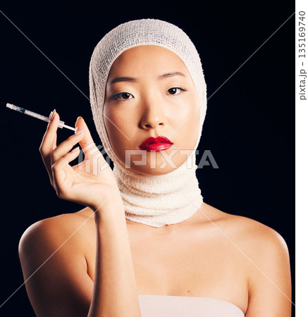 Woman, portrait and plastic surgery with syringe, bandage and studio background with asian beauty for filler. Female person, face and cosmetology with injection for skin, collagen and treatment. 135169740