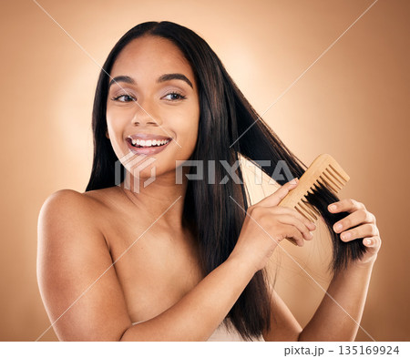 Smile, woman brush her for hair treatment and against a studio background with a glow. Self care, health wellness and cheerful or excited isolated young female person brushing against backdrop Smile, woman brush her for hair treatment and against a studio background with a glow. Self care, health wellness and cheerful or excited isolated young female person brushing against backdrop 135169924