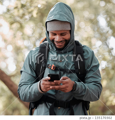 Black man, phone and smile for hiking communication, social media or chat in nature outdoors. Happy African male person or hiker smiling on mobile smartphone for trekking, travel or online location 135170302