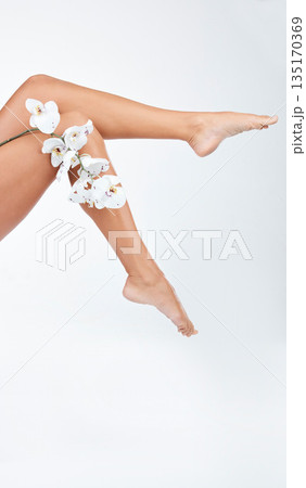 Woman, legs and body with flower, hair removal for skincare and wellness on white background. Female model, natural cosmetics and epilation with organic product for grooming and hygiene in studio Woman, legs and body with flower, hair removal for skincare and wellness on white background. Female model, natural cosmetics and epilation with organic product for grooming and hygiene in studio 135170369