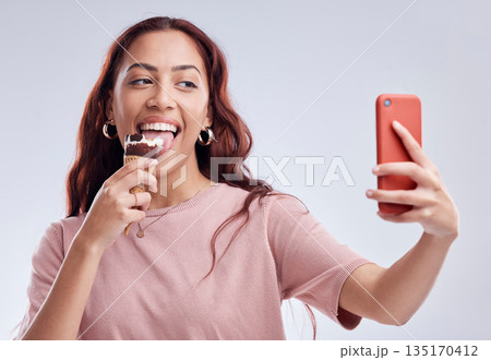 Woman, ice cream and selfie with smile in studio for summer vacation, social media app and blog by white background. Girl, gelato or dessert with photography, profile picture and happy by backdrop Woman, ice cream and selfie with smile in studio for summer vacation, social media app and blog by white background. Girl, gelato or dessert with photography, profile picture and happy by backdrop 135170412