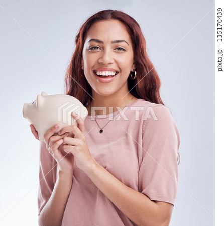 Finance, portrait or happy woman with a piggy bank for financial wealth or savings on white background. Smile, investment or girl laughing or investing cash or budget in tin for safety or security 135170439
