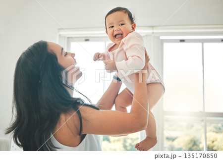 Funny, mother and lifting baby, care and bonding together with infant in home. Smile, mama and raise newborn, child or kid, playing and having fun, happiness or enjoying quality time with family love 135170850