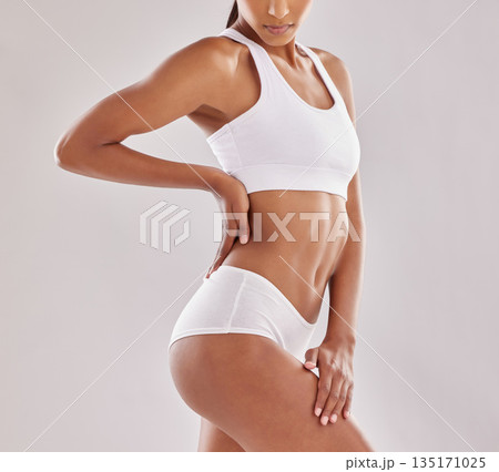 Body, wellness and woman in underwear in studio for diet, positivity and self love on grey background. Detox, beauty and female model with slim, stomach or bodycare in lingerie posing with confidence 135171025