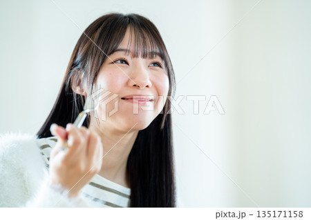 食事をする若い女性 食事をする若い女性 135171158
