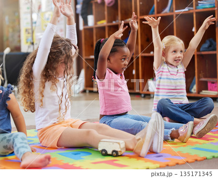 Education, raise hands and children in kindergarten in a classroom for education or knowledge. Daycare, happy and young kid students with a question gesture for learning in lesson together at nursery 135171345