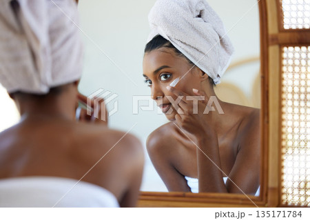 Skincare, beauty and woman with face cream in her bathroom for her morning routine in a mirror. Health, wellness and female person doing a facial treatment with spf, sunscreen or lotion at her home. Skincare, beauty and woman with face cream in her bathroom for her morning routine in a mirror. Health, wellness and female person doing a facial treatment with spf, sunscreen or lotion at her home. 135171784