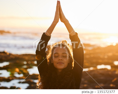 Woman, beach yoga and sunset with pray hands, eyes closed and peace of mind in summer sunshine. Girl, zen meditation and mindfulness for health, wellness and exercise by ocean with stretching outdoor 135172377