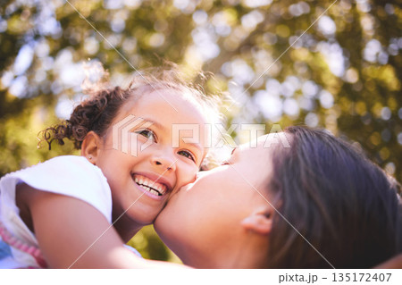 Mother, child and kiss in nature, smile or bonding on summer holiday vacation. Mom, kissing cheek and happy girl, love and affection, care and enjoying quality family time together outdoor in park. Mother, child and kiss in nature, smile or bonding on summer holiday vacation. Mom, kissing cheek and happy girl, love and affection, care and enjoying quality family time together outdoor in park. 135172407