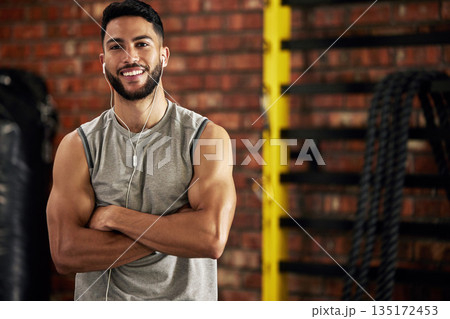 Fitness, earphones and portrait of man in gym, arms crossed and confident smile in mockup space. Happiness, workout and happy face of bodybuilder streaming music for health, indoor training and pride 135172453