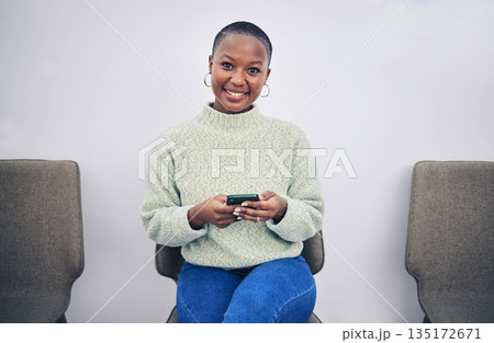 Black woman, phone and portrait on a chair in a waiting room with network connection for social media. African person happy for recruitment interview with a smartphone for internet, website or app Black woman, phone and portrait on a chair in a waiting room with network connection for social media. African person happy for recruitment interview with a smartphone for internet, website or app 135172671