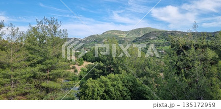 Lush green hills under blue sky 135172959