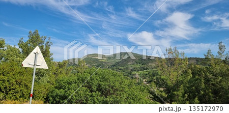 Lush green hills under blue sky 135172970