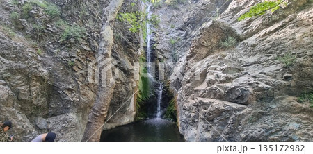 Narrow waterfall in rocky canyon 135172982