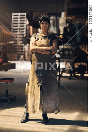 Blacksmith, workshop and portrait of woman with crossed arms for industry, manufacturing and welding. Industrial factory, warehouse and female person for steel, iron and metal production in foundry Blacksmith, workshop and portrait of woman with crossed arms for industry, manufacturing and welding. Industrial factory, warehouse and female person for steel, iron and metal production in foundry 135173066