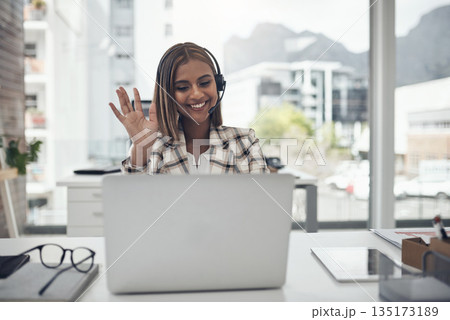 Business woman, headset and laptop for a video call and hand to wave hello on webinar with internet. Female person with technology for communication, online meeting and customer support in an office Business woman, headset and laptop for a video call and hand to wave hello on webinar with internet. Female person with technology for communication, online meeting and customer support in an office 135173189