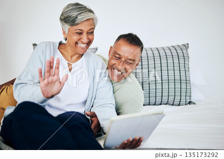 Digital tablet, video call and senior couple speaking, waving and bonding on a sofa in their house. Happy, smile and elderly man and woman in retirement on a virtual conversation with mobile at home. Digital tablet, video call and senior couple speaking, waving and bonding on a sofa in their house. Happy, smile and elderly man and woman in retirement on a virtual conversation with mobile at home. 135173292