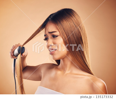 Woman with flat iron, hair care fail and worried about heat damage with hairloss isolated on studio background. Electric straightener, female model with anxiety about keratin treatment and hairstyle 135173332