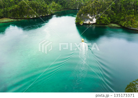 Travel, aerial and boat on island river for adventure, holiday and vacation in Indonesia. Nature, seascape and drone view of yacht in tropical water for transport, sailing and traveling on islands Travel, aerial and boat on island river for adventure, holiday and vacation in Indonesia. Nature, seascape and drone view of yacht in tropical water for transport, sailing and traveling on islands 135173371