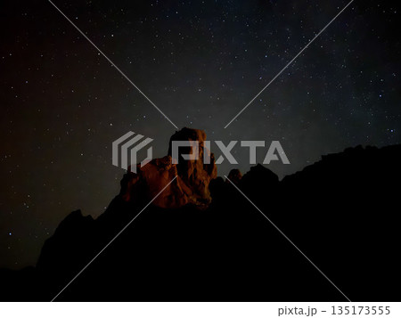 Milky Way and stars above a red-lit volcanic rock peak during nightfall in Teide National Park, Tenerife. 135173555